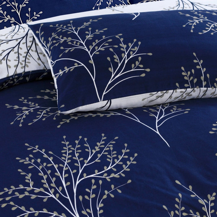Navy blue bedding set with white floral patterns on a bed.